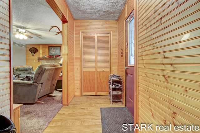 corridor with a textured ceiling and wooden walls