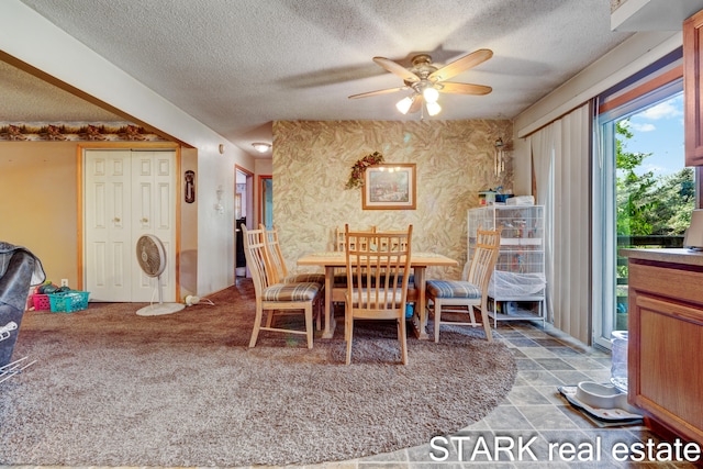 carpeted dining space with a textured ceiling and ceiling fan