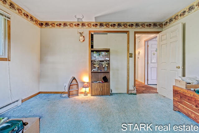 interior space with a baseboard heating unit and carpet flooring