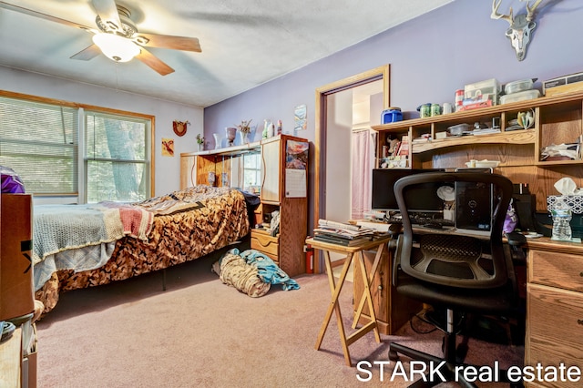 carpeted bedroom with ceiling fan and a textured ceiling