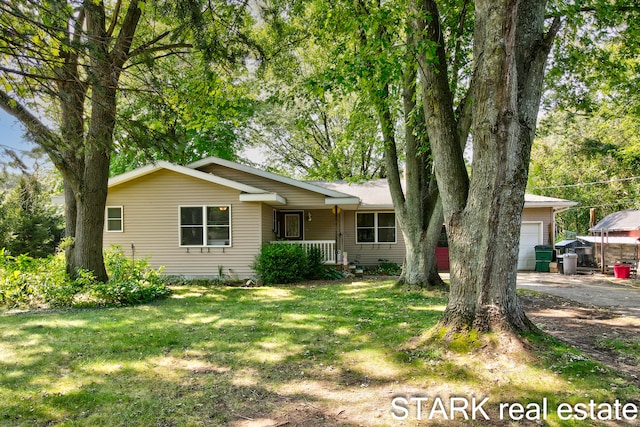 single story home featuring a garage, covered porch, and a front yard