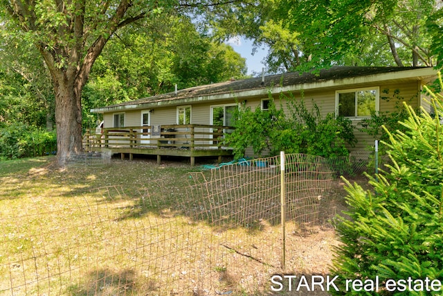 rear view of property with a yard and a deck