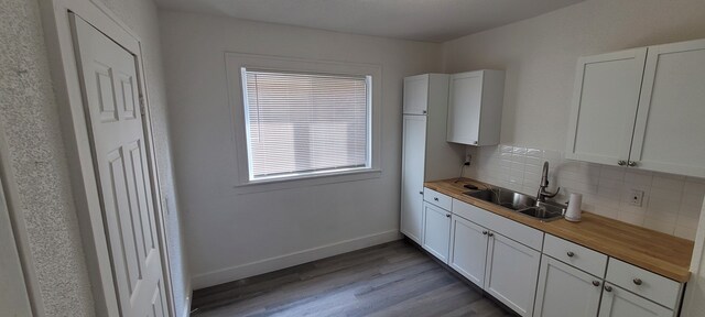 9185 Meyers Rd, Detroit, MI 48228 - kitchen featuring wood counters, a sink, backsplash, light wood-style floors, and white cabinets