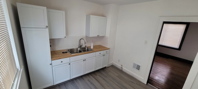 kitchen with sink, white cabinets, wooden counters, and wood-type flooring