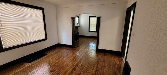 9185 Meyers Rd, Detroit, MI 48228 - spare room with arched walkways, dark wood-style flooring, and baseboards