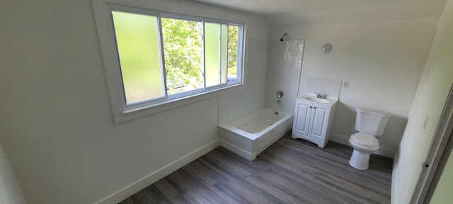 full bathroom with vanity, a textured ceiling, tiled shower / bath combo, hardwood / wood-style flooring, and toilet