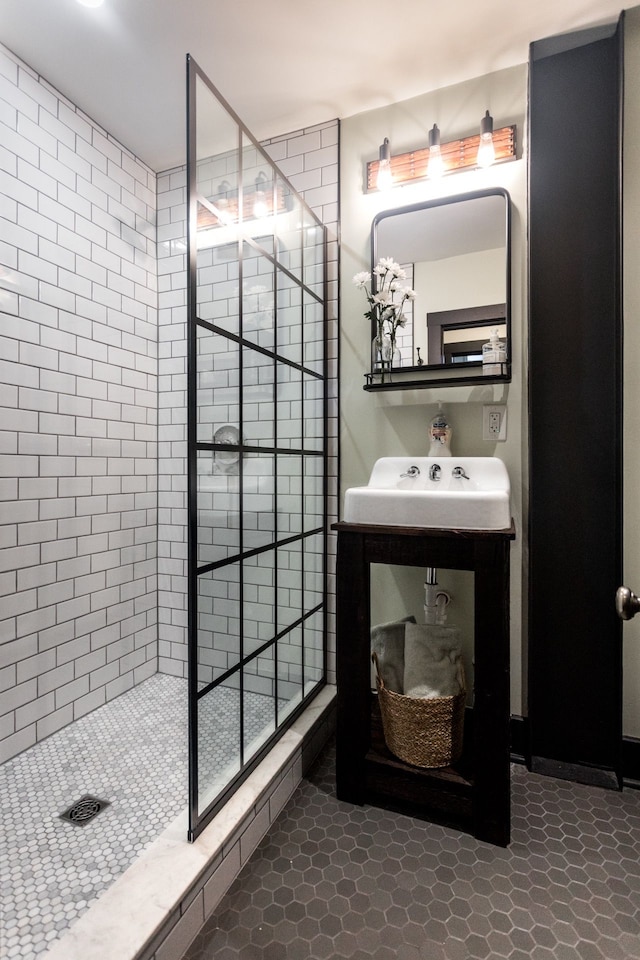 full bath with a tile shower and a sink