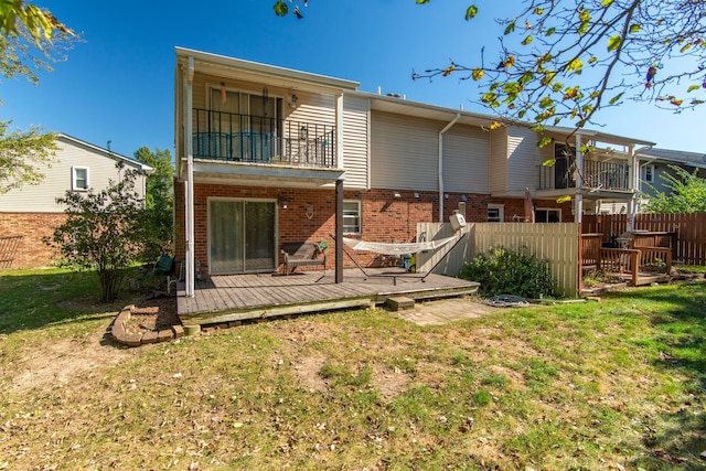 back of house with a balcony, a deck, and a lawn