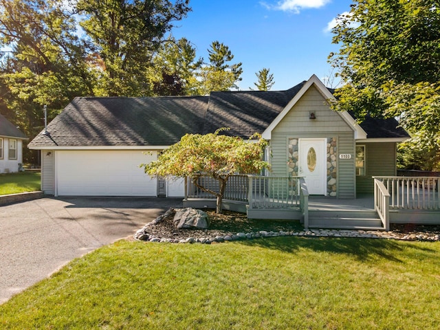 1100 Tisdale Rd, Roscommon, MI 48653 - view of front of property with a front yard, roof with shingles, stone siding, and an attached garage