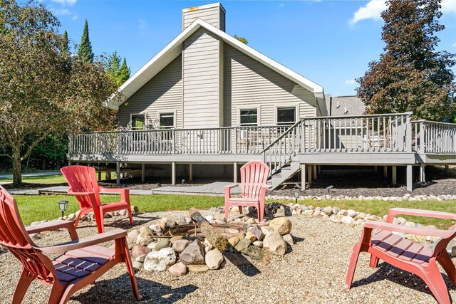 1100 Tisdale Rd, Roscommon, MI 48653 - rear view of property with an outdoor fire pit, a wooden deck, stairs, and a chimney