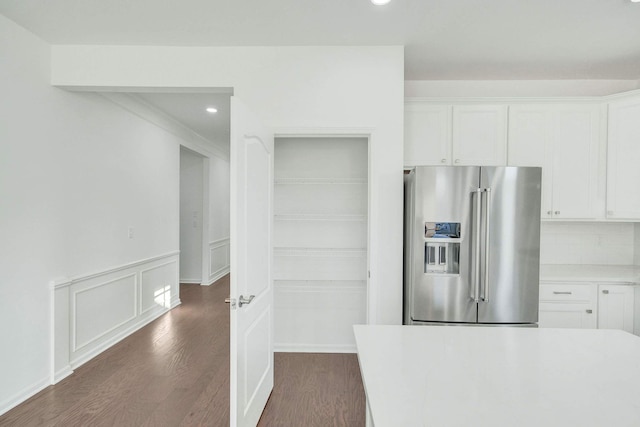 kitchen featuring dark hardwood / wood-style flooring, white cabinetry, high end fridge, and backsplash