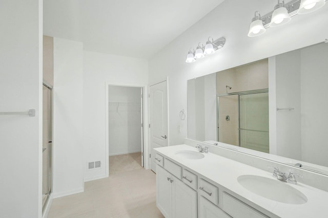 bathroom with tile patterned floors, vanity, and an enclosed shower