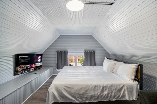 bedroom featuring lofted ceiling, dark wood-type flooring, and wooden walls