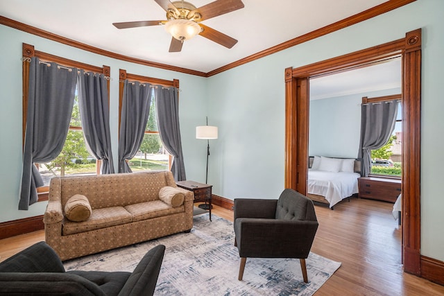 living room featuring hardwood / wood-style floors, ceiling fan, a healthy amount of sunlight, and crown molding