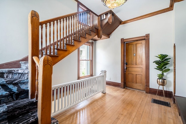 foyer entrance with a chandelier, ornamental molding, and hardwood / wood-style flooring