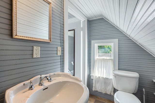 bathroom featuring wooden walls, wood ceiling, lofted ceiling, and toilet