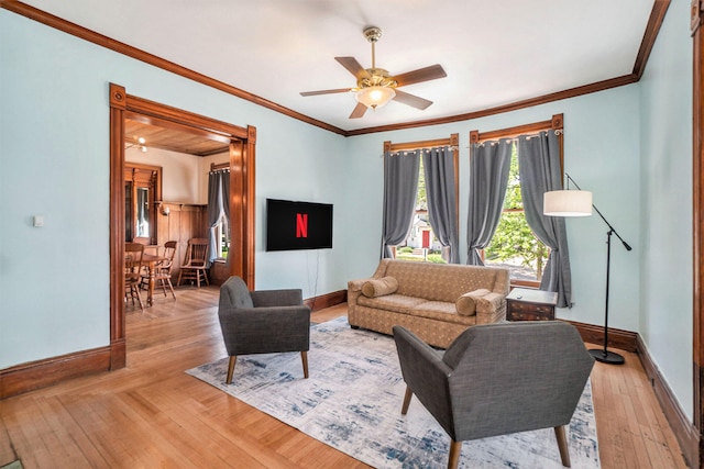 living room with ceiling fan, crown molding, and light hardwood / wood-style floors