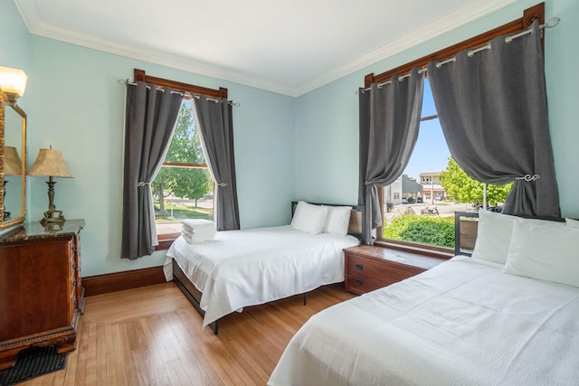 bedroom with light hardwood / wood-style floors and ornamental molding