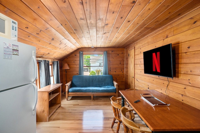 interior space with wood walls, vaulted ceiling, wood ceiling, and light hardwood / wood-style flooring