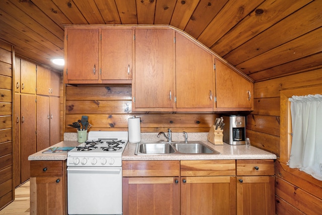 kitchen with sink, wood walls, lofted ceiling, white range with gas cooktop, and wood ceiling