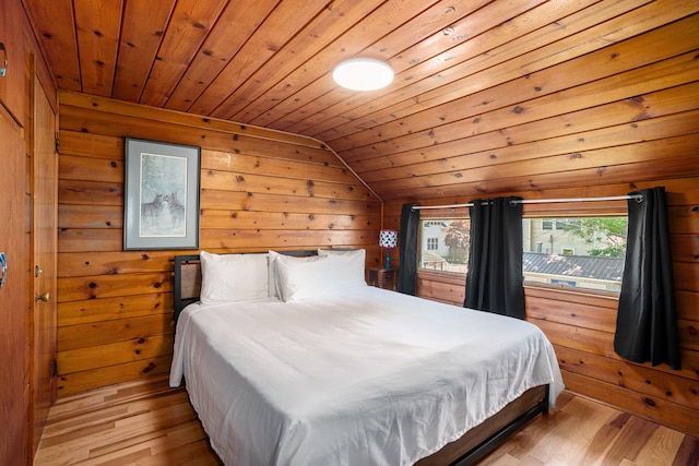 bedroom featuring wood walls, light hardwood / wood-style flooring, wooden ceiling, and lofted ceiling