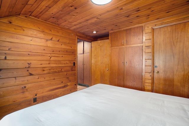 bedroom with lofted ceiling, wood walls, and wood ceiling