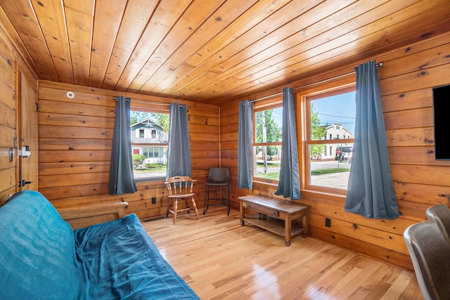 sitting room with wooden walls, light hardwood / wood-style floors, and wooden ceiling