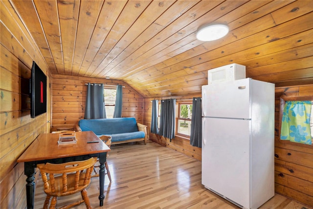 kitchen featuring light hardwood / wood-style floors, lofted ceiling, a healthy amount of sunlight, and white appliances