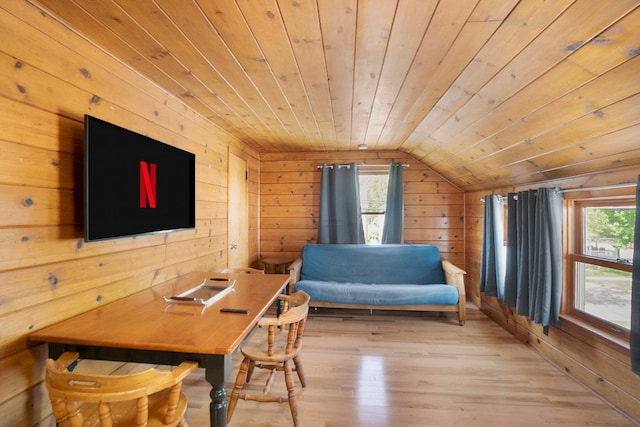 dining space featuring wood walls, light hardwood / wood-style floors, lofted ceiling, and wood ceiling