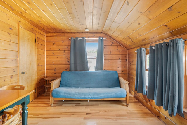 living area featuring light wood-type flooring, wooden walls, lofted ceiling, and wood ceiling