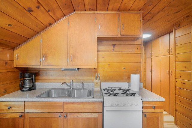 kitchen featuring white gas stove, sink, vaulted ceiling, wooden walls, and wood ceiling