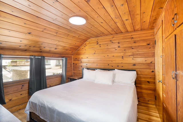 bedroom featuring wooden walls, light hardwood / wood-style flooring, wooden ceiling, and lofted ceiling