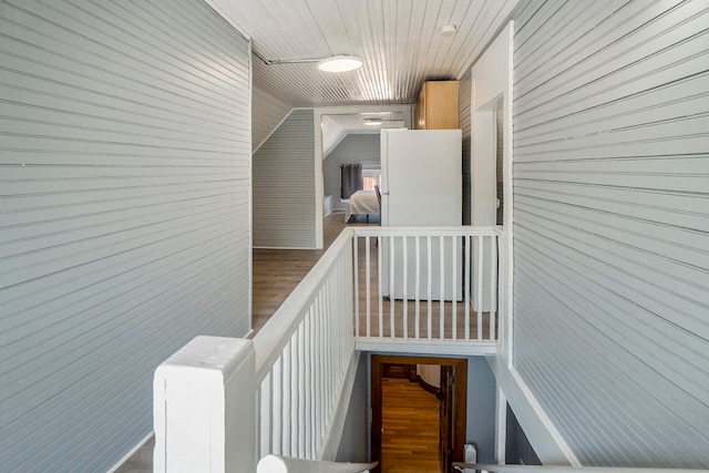 stairs featuring hardwood / wood-style floors, wooden ceiling, and vaulted ceiling