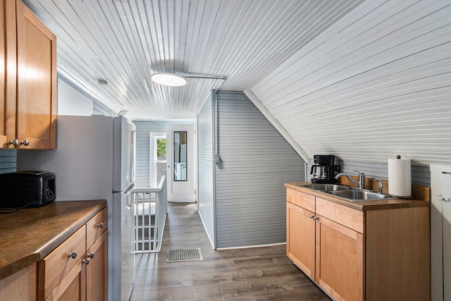 kitchen featuring wooden ceiling, dark wood-type flooring, sink, wooden walls, and vaulted ceiling