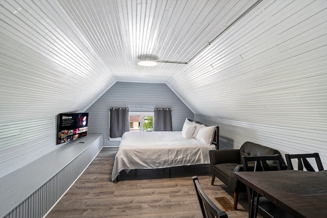 bedroom featuring hardwood / wood-style floors, wood walls, and vaulted ceiling