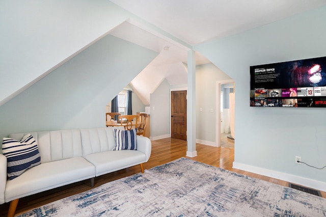 living room featuring wood-type flooring and lofted ceiling