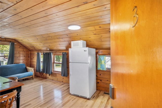 kitchen with white appliances, light hardwood / wood-style floors, a wealth of natural light, and lofted ceiling