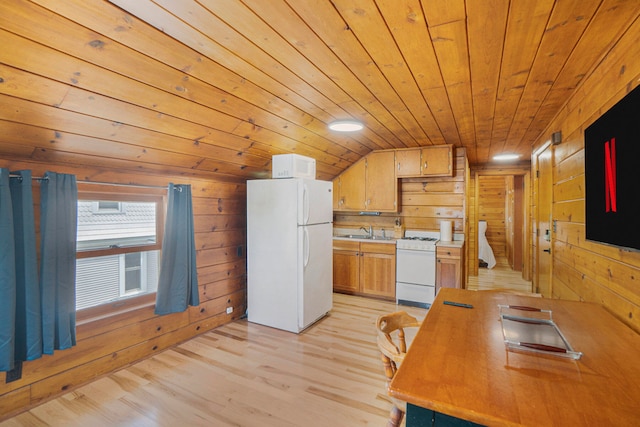 kitchen with white appliances, sink, wooden walls, vaulted ceiling, and light wood-type flooring