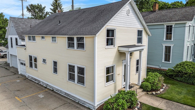 rear view of property with a garage