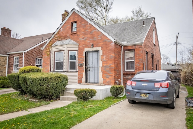 8594 Lauder St, Detroit, MI 48228 - view of front facade with roof with shingles, brick siding, and a chimney