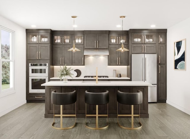 kitchen featuring white fridge, a healthy amount of sunlight, and a kitchen island with sink