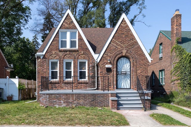 english style home with a front lawn