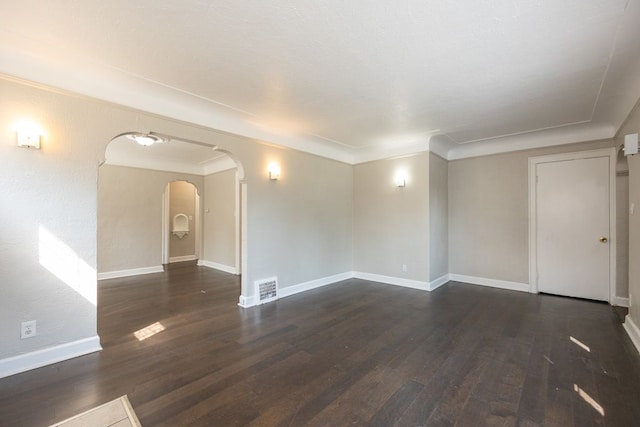 empty room with dark hardwood / wood-style flooring and ornamental molding