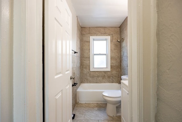 full bathroom with tiled shower / bath, vanity, and toilet