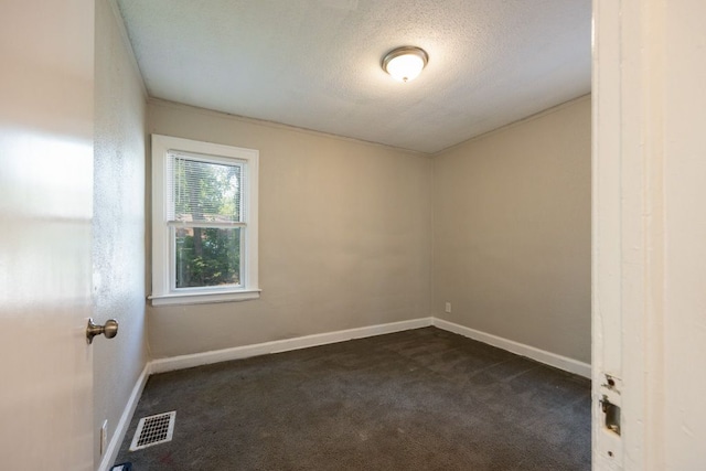 unfurnished room with dark carpet and a textured ceiling