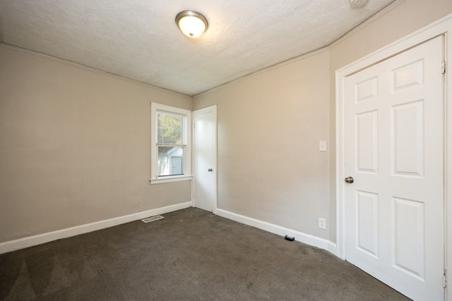 carpeted empty room with a textured ceiling