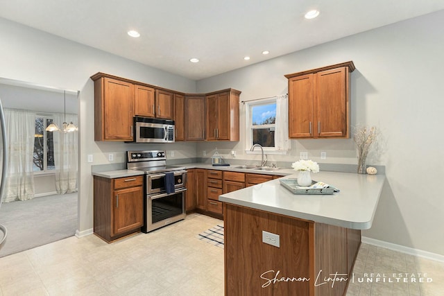 kitchen with sink, hanging light fixtures, a notable chandelier, kitchen peninsula, and appliances with stainless steel finishes