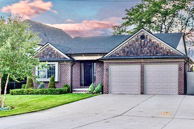 view of front of property with driveway, an attached garage, brick siding, a shingled roof, and a yard