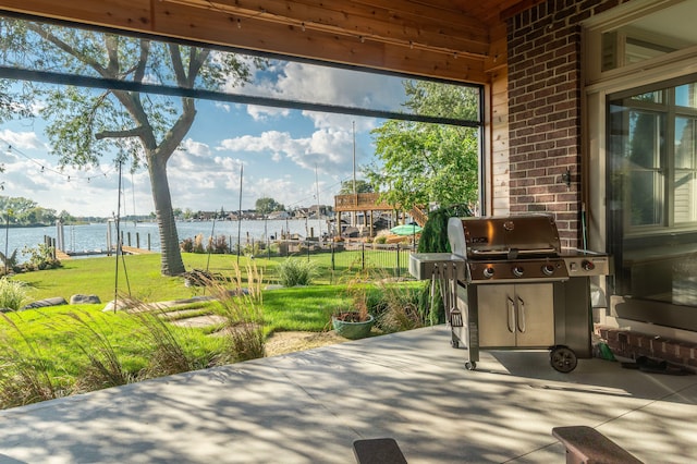 view of patio / terrace with area for grilling, a water view, and fence