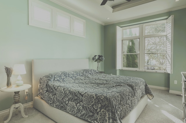 carpeted bedroom with baseboards, ornamental molding, a tray ceiling, and a ceiling fan